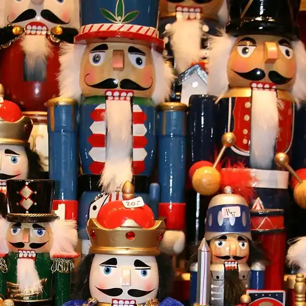 Colorful nutcracker soldiers in various designs and heights, arranged closely together.